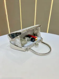 Elegant rhinestone evening clutch bag with metal handle, luxury sparkling party handbag for women.