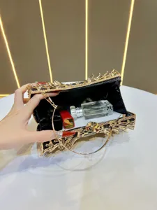 Close-up view of the sparkling rhinestone evening clutch interior, detailed metal handle craftsmanship.