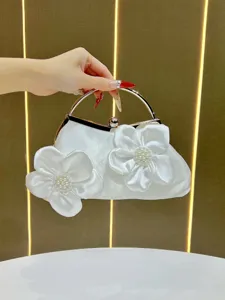 Sac à main de soirée en satin blanc avec poignée de fleur de perle, détail de pochette élégante.