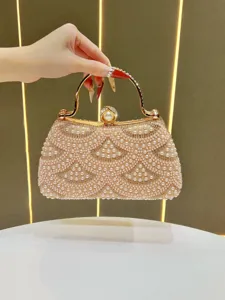 Close-up detail of luxurious pearl rhinestone evening clutch bag with elegant gold clasp lock.
