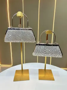 Detail view of glittering rhinestone evening bag, luxury metal handle and sparkling diamond crystals.