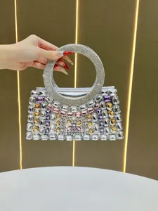Detailed view of luxury rhinestone evening bag, sparkling crystals and unique round handle.