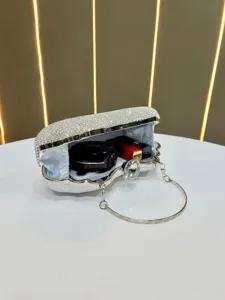 Silver rhinestone evening clutch bag close-up showing interior space and crystal details.