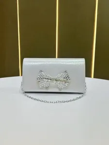 Exquisite rhinestone bow silver clutch bag detail, elegant evening handbag with chain strap.