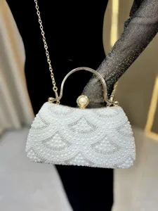 Detailed view of luxury pearl rhinestone evening clutch bag with metal handle and chain strap.