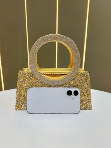 Close-up detail of luxury gold rhinestone evening bag featuring a sparkling circular handle.