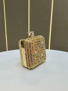 Close-up detail view of a glittering rhinestone box clutch bag with gold frame and crystal lock.
