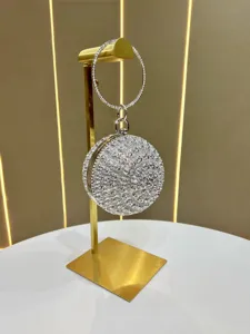 Sparkling crystal round evening bag detail, featuring rhinestone rose pattern and metal ring handle.