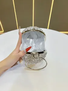 Detail view of sparkly rhinestone round evening bag with satin lining and metal ring handle.