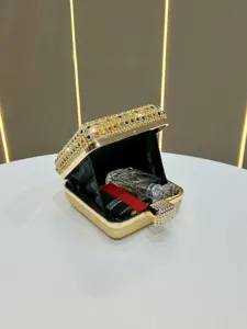 Luxurious crystal evening clutch bag with gold metallic frame and rhinestones for parties.
