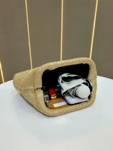 Detailed view of large capacity straw woven clutch bag with daily essentials inside.