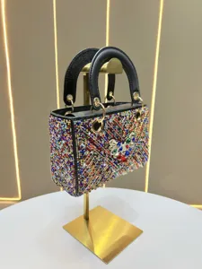 Sac à main de soirée luxueux en strass avec cristaux colorés et poignées rigides.