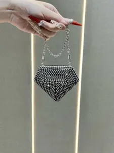 Close-up detail of the sparkling rhinestone mini evening bag, featuring a geometric diamond shape.