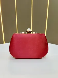 Rote Satin Abendtasche Detailansicht mit Perlenverschluss und goldenem Rahmen für festliche Anlässe.