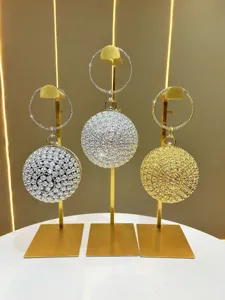 Close-up detail of luxury crystal rhinestone round ball evening bag with circular metal handle.