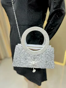 Sparkling rhinestone evening bag detail with crystal round handle and elegant silver chain.