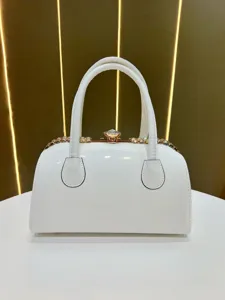 White patent leather handbag with gold frame crystal clasp and chain strap for women.