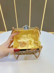 Detail view of a luxury gold rhinestone evening clutch bag with flower crystal clasp.