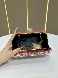 Exquisite red velvet evening clutch detail showing rhinestone embellishments and gold frame.