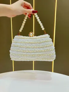 Elegant white beaded evening clutch bag with pearl handle and stylish lace texture detail.