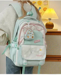 Détail de sac à dos d'étudiant vert menthe avec design élégant, poches multiples et jolie petite pochette.