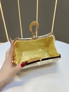 Primo piano di un'elegante pochette da sera con manico in strass e dettagli dorati