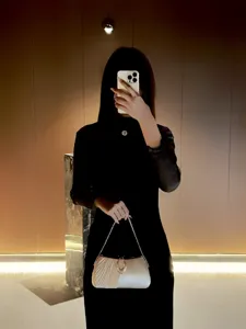 Elegante borsa da sera a pieghe con catena e chiusura ad anello di strass, ideale per feste.