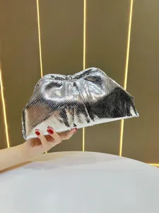 Détail de pochette argentée, sac de soirée élégant avec design froncé tendance.