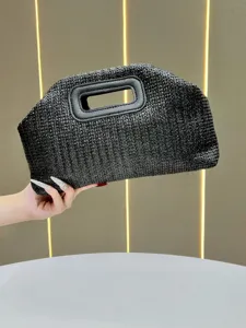 Black straw woven clutch bag for women, stylish summer handbag with cutout handle design.