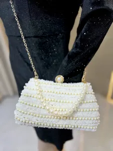 White lace beaded evening clutch bag detail with pearl handle and gold chain strap elegant