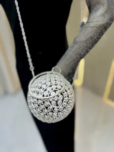 Exquisite crystal ball evening bag close-up, showcasing sparkling rhinestone rose details and chain.