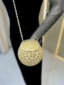 Close-up detail of the luxury gold rhinestone rose spherical evening bag with chic chain.