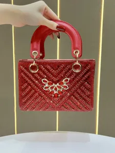 Détail de sac à main de soirée en strass rouges, cristaux et quincaillerie dorée.
