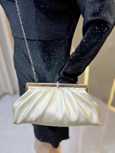Gold evening clutch bag detail showing metallic frame and chain strap for women party wear.
