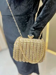 Close-up detail of the luxurious gold rhinestone evening clutch bag with chain strap.