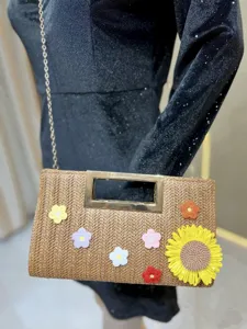 Straw woven detail shot showing the elegant chain handbag with cute crochet flower decor.