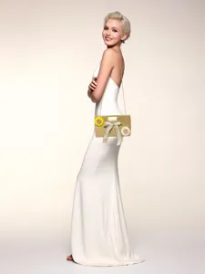 Detailed view of a chic woven straw shoulder bag with chain strap and floral bow decoration.