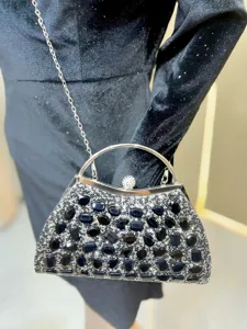 Black rhinestone evening clutch detail showcasing sparkly crystals and silver metal handle.