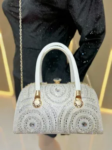 Close-up detail of luxury rhinestone evening bag with sparkling crystals and gold hardware.