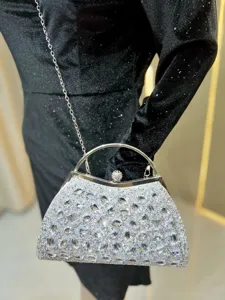 Crystal evening bag detail showcasing sparkling rhinestones, metal handle and delicate chain strap.