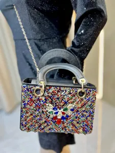 Vue détaillée d'un sac à main de soirée de luxe en strass avec papillon et chaîne en métal.