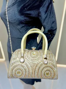Detail view of a luxury rhinestone evening bag with sparkling crystals, top handle and chic chain.