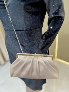 Detailed view of elegant women's evening clutch bag with metallic chain and rhinestones.