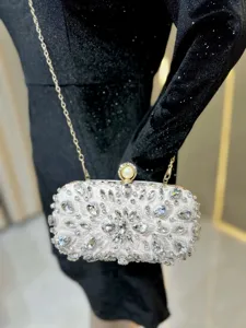 Detailed view of the sparkling rhinestone evening clutch bag with pearl clasp and chain.