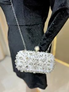 Exquisite rhinestone evening clutch bag with pearl clasp and silver chain detail closeup.