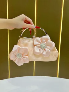 Vue détaillée d'une pochette de soirée en satin avec fleurs de perles et poignée en métal chic