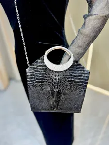 Elegante borsa da sera nera con motivo coccodrillo, manico rotondo in strass e catena.