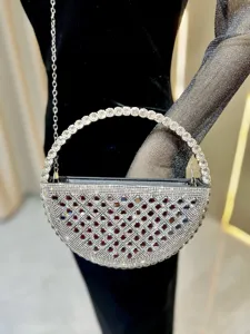 Dettaglio in primo piano della lussuosa borsa da sera in strass con manico rotondo.