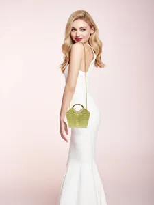 Dettaglio di una borsa da sera coccodrillo verde, con catena metallica e manico strass.