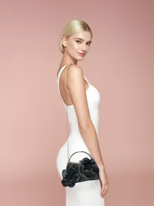 Pochette de soirée noire élégante avec applications florales, poignée métal et chaîne.
